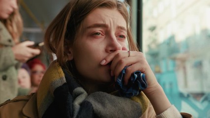 Woman blowing her nose into handkerchief on the tram on a cold autumn day at the start of the flu season disease fever flu grippe health illness infection influenza migraine sickness slow motion