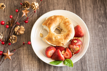 Holiday Themed Breakfast of Bagel and Strawberries on Wooden Table
