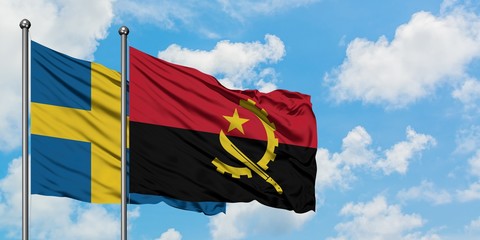 Sweden and Angola flag waving in the wind against white cloudy blue sky together. Diplomacy concept, international relations.