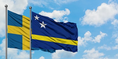 Sweden and Curacao flag waving in the wind against white cloudy blue sky together. Diplomacy concept, international relations.