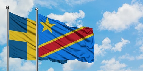 Sweden and Congo flag waving in the wind against white cloudy blue sky together. Diplomacy concept, international relations.