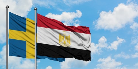 Sweden and Egypt flag waving in the wind against white cloudy blue sky together. Diplomacy concept, international relations.