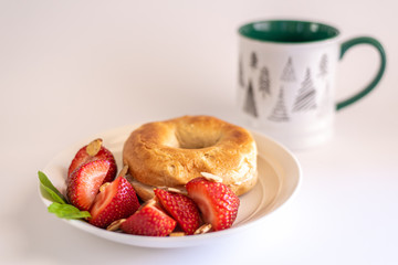 Bagel with Strawberries on White Plate with Coffee Mug