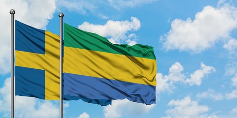 Sweden and Gabon flag waving in the wind against white cloudy blue sky together. Diplomacy concept,...