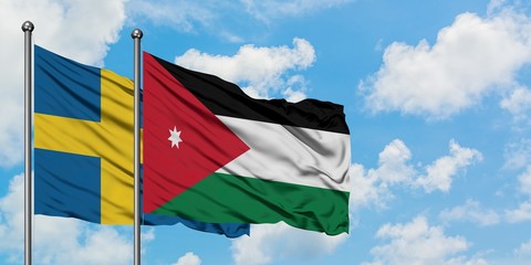 Sweden and Jordan flag waving in the wind against white cloudy blue sky together. Diplomacy concept, international relations.