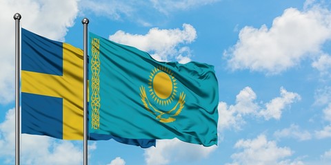 Sweden and Kazakhstan flag waving in the wind against white cloudy blue sky together. Diplomacy concept, international relations.