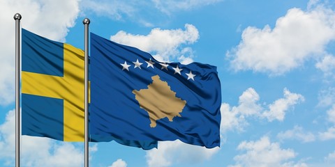 Sweden and Kosovo flag waving in the wind against white cloudy blue sky together. Diplomacy concept, international relations.