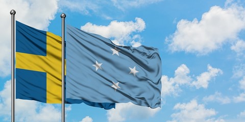 Sweden and Micronesia flag waving in the wind against white cloudy blue sky together. Diplomacy concept, international relations.