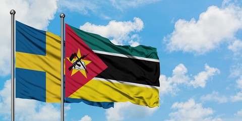 Sweden and Mozambique flag waving in the wind against white cloudy blue sky together. Diplomacy concept, international relations.