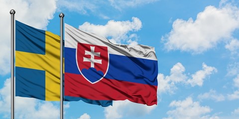 Sweden and Slovakia flag waving in the wind against white cloudy blue sky together. Diplomacy concept, international relations.