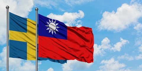 Sweden and Taiwan flag waving in the wind against white cloudy blue sky together. Diplomacy concept, international relations.