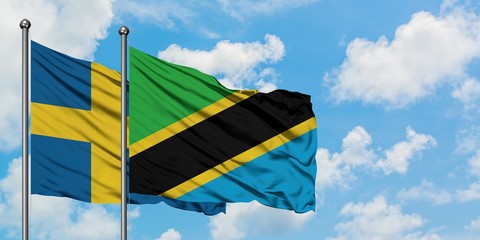 Sweden and Tanzania flag waving in the wind against white cloudy blue sky together. Diplomacy concept, international relations.