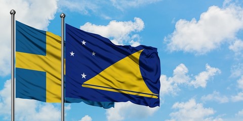 Sweden and Tokelau flag waving in the wind against white cloudy blue sky together. Diplomacy concept, international relations.