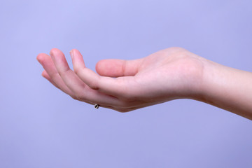 Open a woman's hand, palm up isolated on blue background