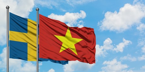 Sweden and Vietnam flag waving in the wind against white cloudy blue sky together. Diplomacy concept, international relations.