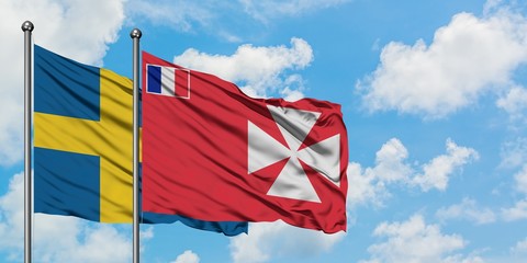 Sweden and Wallis And Futuna flag waving in the wind against white cloudy blue sky together. Diplomacy concept, international relations.