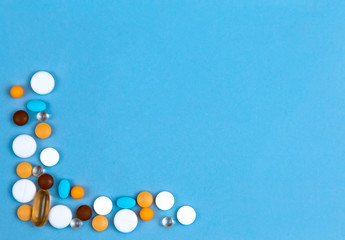 Pills Set As Border. Colored pills set as border on blue background with copy space for text.