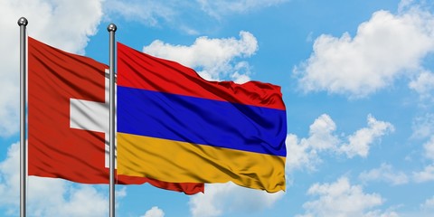Switzerland and Armenia flag waving in the wind against white cloudy blue sky together. Diplomacy concept, international relations.