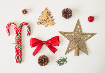 Holiday stuff, candies, ribbons, christmas decorations and pine cone on white background. Set of objects.