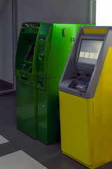 Automated Teller Machine. Two yellow and green ATMs in the lobby of the shopping center.