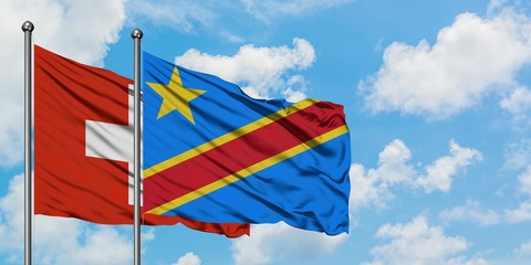 Switzerland and Congo flag waving in the wind against white cloudy blue sky together. Diplomacy concept, international relations.