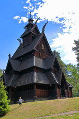 Little two years old boy running and playing in front of the Gol Church,  a stave church originally...
