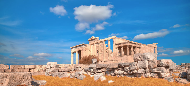 Panoramic image of Erechtheion temple Acropolis, Athens, Greece, with famous Caryatides in Autumn with orange grass and blue sky with clouds