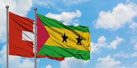 Switzerland and Sao Tome And Principe flag waving in the wind against white cloudy blue sky together. Diplomacy concept, international relations.