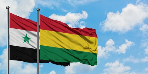 Syria and Bolivia flag waving in the wind against white cloudy blue sky together. Diplomacy concept, international relations.