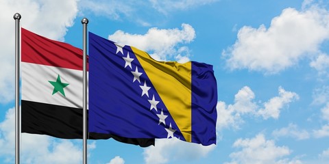 Syria and Bosnia Herzegovina flag waving in the wind against white cloudy blue sky together. Diplomacy concept, international relations.