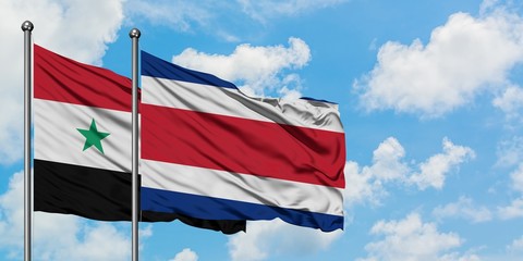 Syria and Costa Rica flag waving in the wind against white cloudy blue sky together. Diplomacy concept, international relations.