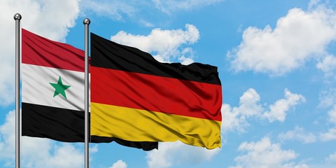 Syria and Germany flag waving in the wind against white cloudy blue sky together. Diplomacy concept, international relations.