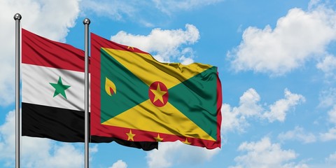 Syria and Grenada flag waving in the wind against white cloudy blue sky together. Diplomacy concept, international relations.