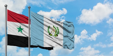 Syria and Guatemala flag waving in the wind against white cloudy blue sky together. Diplomacy concept, international relations.
