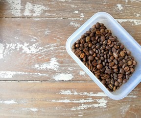 Coffee been roasting in the plastic box on the wood table in the coffee cafe shop.