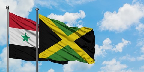 Syria and Jamaica flag waving in the wind against white cloudy blue sky together. Diplomacy concept, international relations.