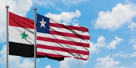 Syria and Liberia flag waving in the wind against white cloudy blue sky together. Diplomacy concept, international relations.