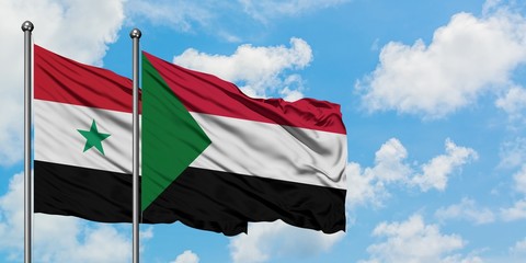 Syria and Sudan flag waving in the wind against white cloudy blue sky together. Diplomacy concept,...