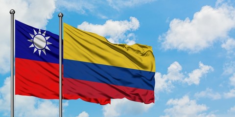 Taiwan and Colombia flag waving in the wind against white cloudy blue sky together. Diplomacy concept, international relations.