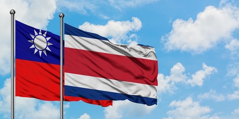 Taiwan and Costa Rica flag waving in the wind against white cloudy blue sky together. Diplomacy concept, international relations.