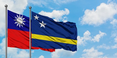 Taiwan and Curacao flag waving in the wind against white cloudy blue sky together. Diplomacy concept, international relations.