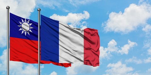 Taiwan and France flag waving in the wind against white cloudy blue sky together. Diplomacy concept, international relations.