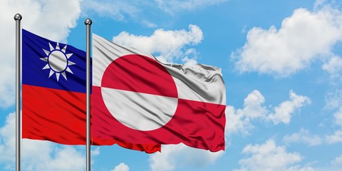 Taiwan and Greenland flag waving in the wind against white cloudy blue sky together. Diplomacy concept, international relations.