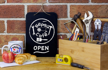 Repair cafe sign on chalk board on table with tools and coffee mug, sustainable living concept the right to repair consumer goods to reduce waste