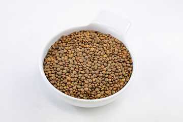 Top view of a bowl with lentils on white background