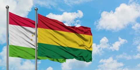 Tajikistan and Bolivia flag waving in the wind against white cloudy blue sky together. Diplomacy concept, international relations.
