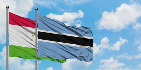 Tajikistan and Botswana flag waving in the wind against white cloudy blue sky together. Diplomacy concept, international relations.