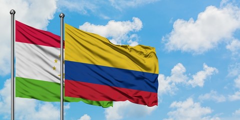 Tajikistan and Colombia flag waving in the wind against white cloudy blue sky together. Diplomacy concept, international relations.