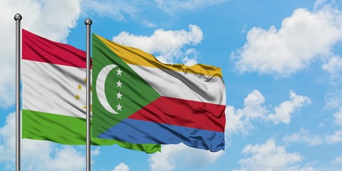 Tajikistan and Comoros flag waving in the wind against white cloudy blue sky together. Diplomacy concept, international relations.