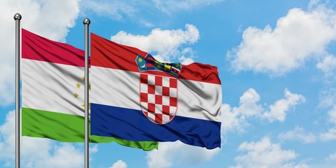 Tajikistan and Croatia flag waving in the wind against white cloudy blue sky together. Diplomacy concept, international relations.